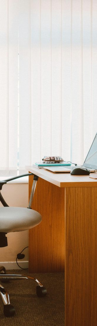 A tranquil modern home office featuring a wooden desk, ergonomic chair, and soft natural light.